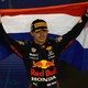 Max Verstappen holds a Dutch flag over his head